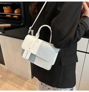 Detail of color-block flap crossbody bag with top handle and Fashion & Bags decorative tag