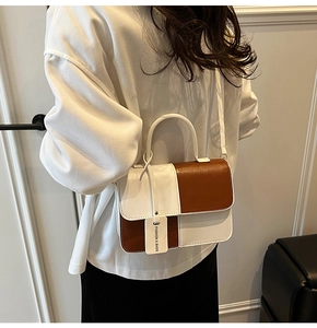 Detailed view of color-block leather crossbody bag worn by a model in lifestyle setting