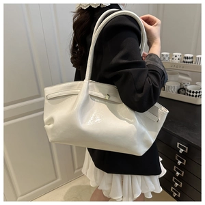 Detail einer weißen glänzenden Shopper-Tasche mit modischen Falten und Metallschnalle