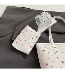 Dettaglio del set borsa floreale con stampe ciliegie e fiocchi rossi su blazer grigio