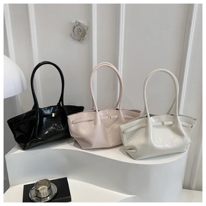 Drei glänzende Lackleder-Shopper in Schwarz, Rosa und Creme mit goldenen Schnallen
