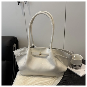 Detail der cremefarbenen Ledertasche mit goldener Schnalle und eleganter Faltenstruktur