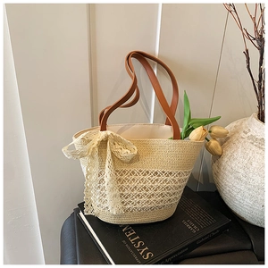 Detailed close-up of woven tote bag featuring beige lace bow and diamond mesh texture
