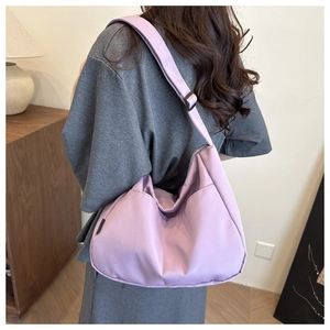 Back view of a large lavender nylon tote bag showing its oversized slouchy fit on a model
