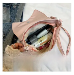 Vue détaillée de l'intérieur du sac à nœud rose montrant le compartiment et les essentiels