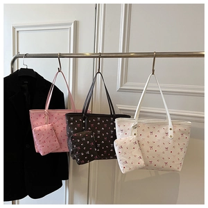Dettaglio della borsa tote floreale con motivo a ciliegie, con pochette piccola e manici sottili