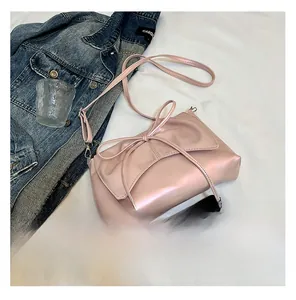 Gros plan du sac à bandoulière rose nacré style ballet avec détail de nœud élégant