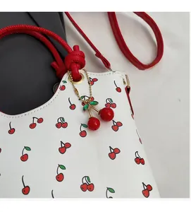 Détail du sac blanc avec imprimé cerises et charm pendentif cerise assorti