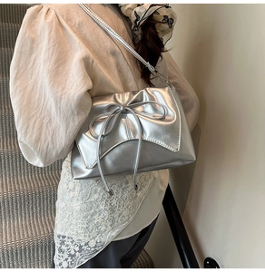 Gros plan sur le sac à bandoulière argenté à nœud avec texture plissée et allure tendance