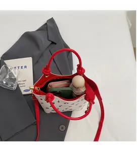 Vue intérieure du sac seau à motif cerise montrant l'espace pour téléphone et portefeuille