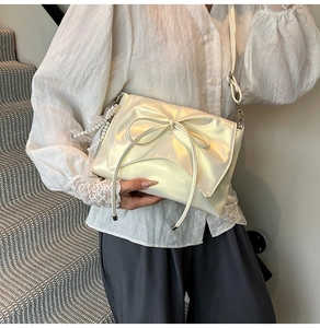 Sac bandoulière beige chic avec grand nœud et breloque en dentelle de perles sur modèle
