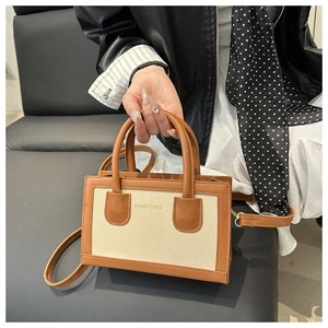 Detail of contrast stitch woven tote bag with premium leather trim and vintage typography
