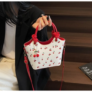 Détail du sac à main imprimé cerise avec poignée rouge et charmant pendentif cerise 3D