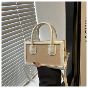 Detail view of mini tote bag with white leather and beige canvas contrast and gold logo