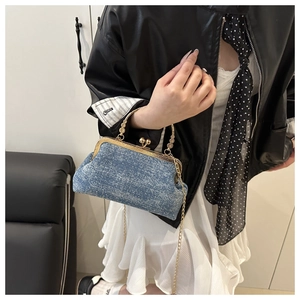 Detail of vintage denim frame bag with gold handle and chain strap for luxury styling