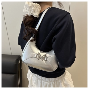 Détail du sac à bandoulière argenté en demi-lune avec boucle papillon et effet miroir
