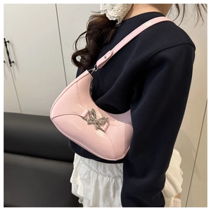 Détail du sac demi-lune en cuir verni rose avec une boucle papillon argentée