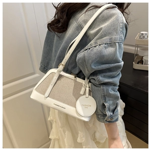 Detail of white leather and canvas shoulder bag showing textured material and fashion print