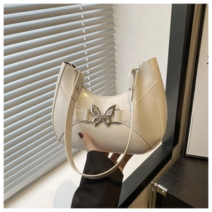 Détail du sac hobo blanc crème en cuir texturé avec boucle papillon argentée