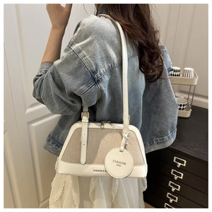 Side view of model wearing a vintage linen-stitch boston bag with leather straps