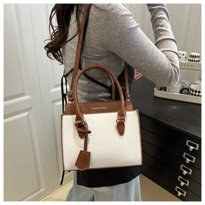 Detail of lychee pattern leather handbag in white and brown with a designer hanging tag