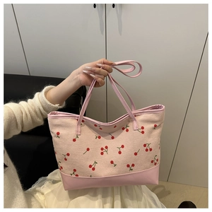 Détail du sac cabas rose imprimé cerises avec coutures en velours côtelé et similicuir