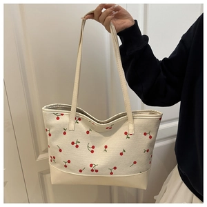 Détail du sac cabas en velours avec motifs cerises rouges et anses blanches solides