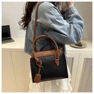 Chic two-tone crossbody bag for women in black and brown displayed on a desk