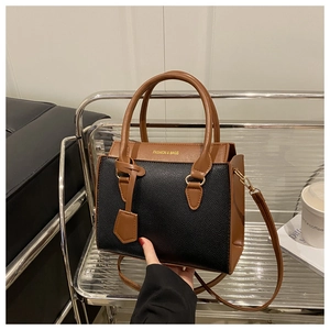 Détail du sac cabas bicolore avec texture litchi et ferrures en métal doré
