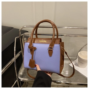Détail de la texture grainée du sac à main bicolore violet et marron contrasté