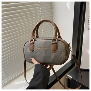 Gray Boston bag with brown leather handles and adjustable shoulder strap for women