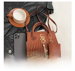 Close-up of vintage brown crocodile texture bag with gold S-pendant and small coin purse