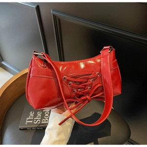 Close-up of bright red patent leather shoulder bag with vintage ribbon bow decoration