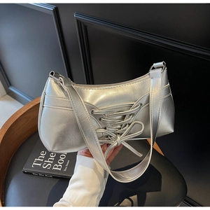Close-up of metallic silver bag with lace-up bow detail and polished finish