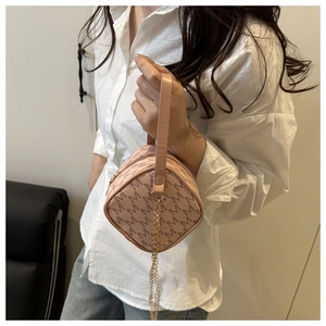Détail du sac à main rose avec monogramme, chaîne dorée et finition en cuir texturé