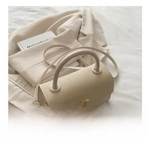 Close-up of beige woven texture handbag featuring elegant golden triangle metal buckle lock