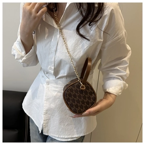 Detailed view of mini round brown bag with letter print and gold chain strap
