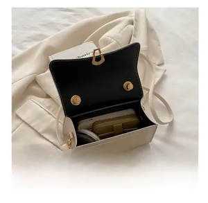 Internal view of cream white flap bag showing capacity for phone and wallet with gold lock