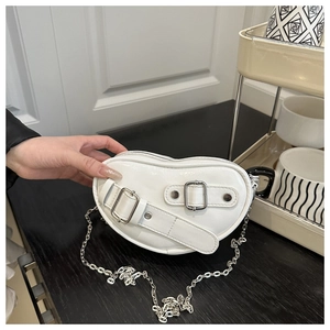 White heart-shaped underarm bag with silver buckle straps and chain strap detail