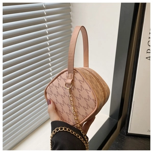 Détail d'un mini sac jacquard rose à monogramme avec chaîne dorée et poignée