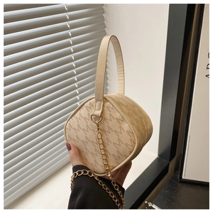 Détail du sac demi-lune beige avec motif monogramme M et bandoulière chaîne dorée