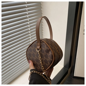 Détail du mini sac bandoulière en cuir marron avec motif de lettres et chaîne dorée