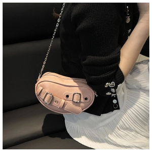 Detail of pink PU leather heart-shaped crossbody bag with silver chain and buckles