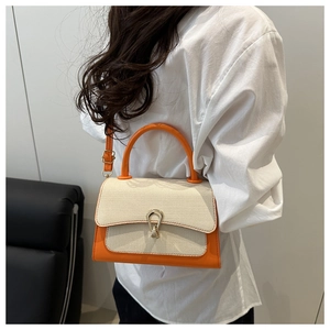 Detail of orange and beige textured crossbody bag featuring a horseshoe metal buckle clasp