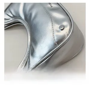 Detailed close-up of metallic silver moon bag showing fine texture and FASH logo