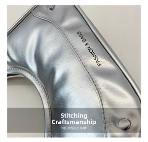Macro view of silver metallic leather texture with rivet details and fashion logo stitching