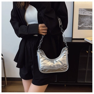 Detail of silver crescent shoulder bag with metallic finish and metal chain strap