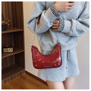 Detail of burgundy crescent moon bag with silver chain and FASHION & BAGS text logo