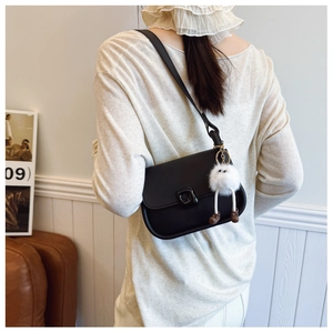 Sac bandoulière en cuir noir avec boucle en métal et adorable porte-clé monstre blanc