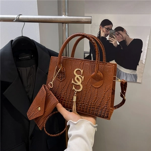 Brown crocodile pattern handbag with gold logo, tassel pendant and small coin purse charm